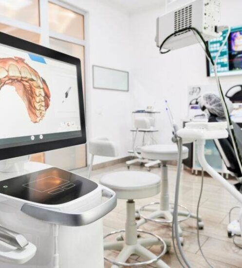 Interior of dental office with modern equipment and dental intraoral scanner with teeth on display, medical system for intraoral scanning. Concept of digital dentistry and dental scanning technology.